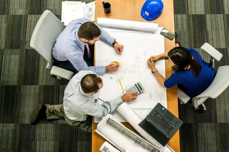 Réunion d'architectes et coordinateur SPS autour d'un plan de chantier à Le Mans